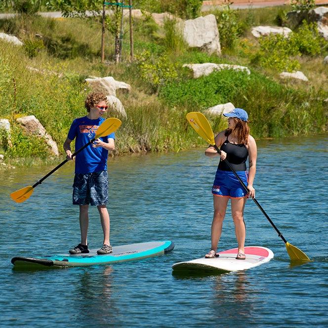 Two students paddleboard on Boise River